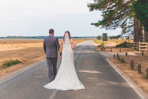 wedding photography by j lawrence bride and groom walking down a road